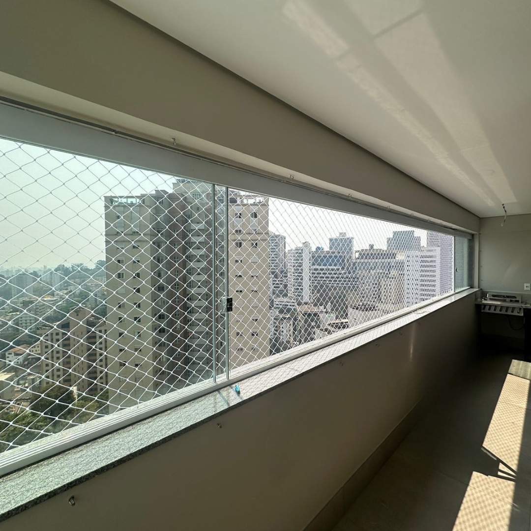 Rede de proteção instalada em sacada alta com vista urbana em Belo Horizonte — segurança com acabamento discreto