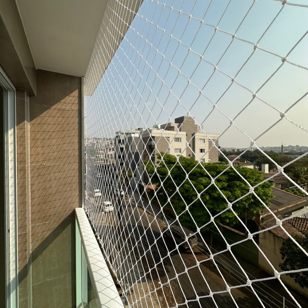 Rede de proteção instalada em sacada alta com vista urbana em Belo Horizonte — segurança com acabamento discreto