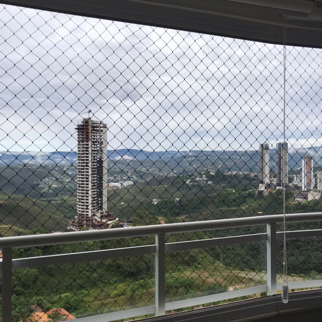 Rede de proteção instalada em sacada alta com vista urbana em Belo Horizonte — segurança com acabamento discreto