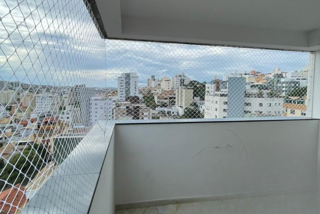 Rede de proteção instalada em sacada de apartamento alto com vista da cidade de Belo Horizonte — segurança sem comprometer a estética